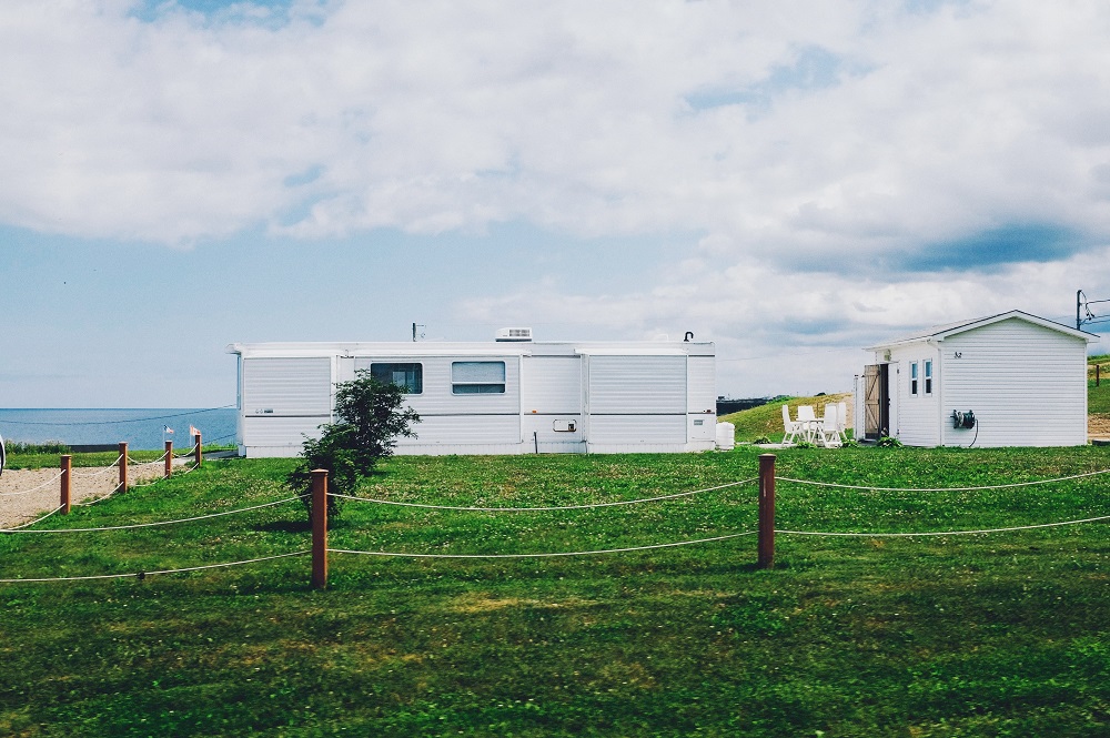 witte stacaravans, tiny house bij strand in gras