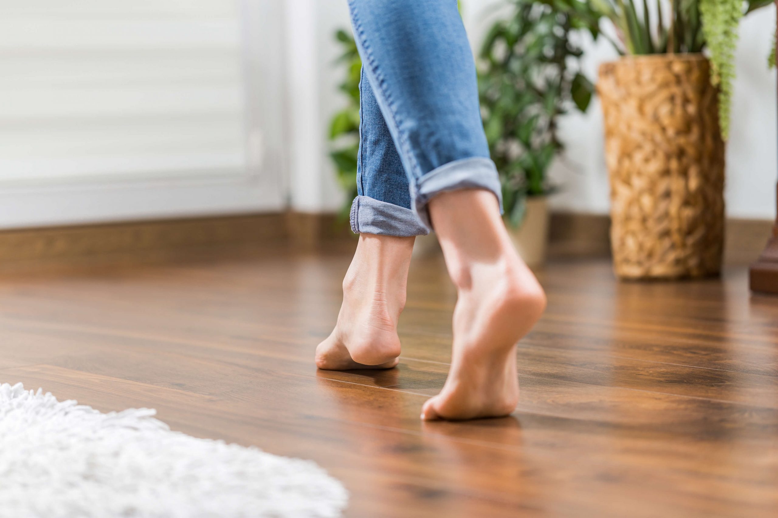 blote vrouwenvoet op laminaat vloer met vloerverwarming